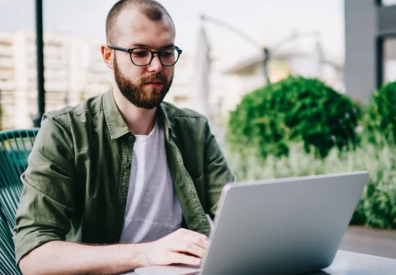 millenial man at laptop PTSD caregiver